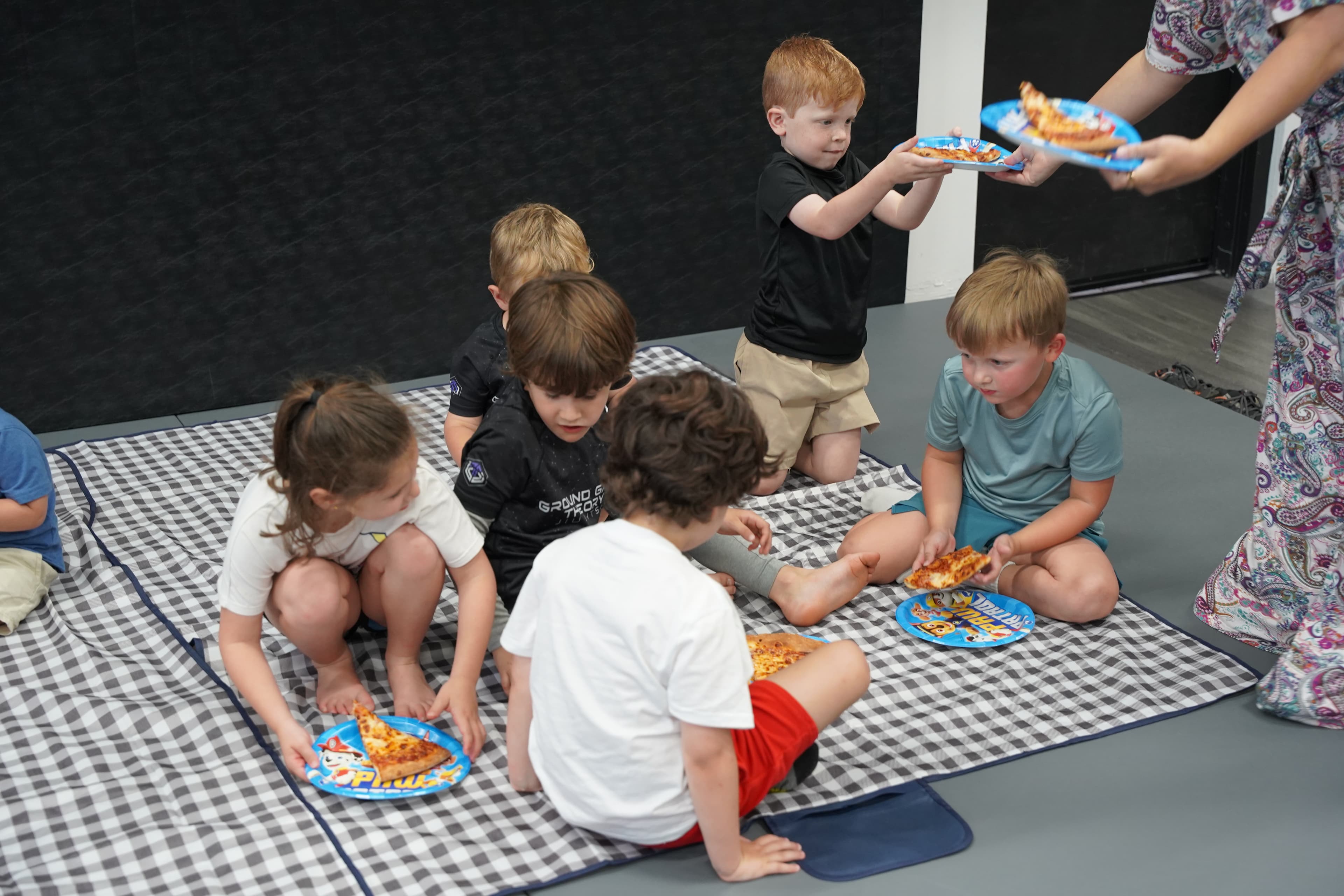 Kids eating pizza at a birthday party at Ground Game Theory Miami