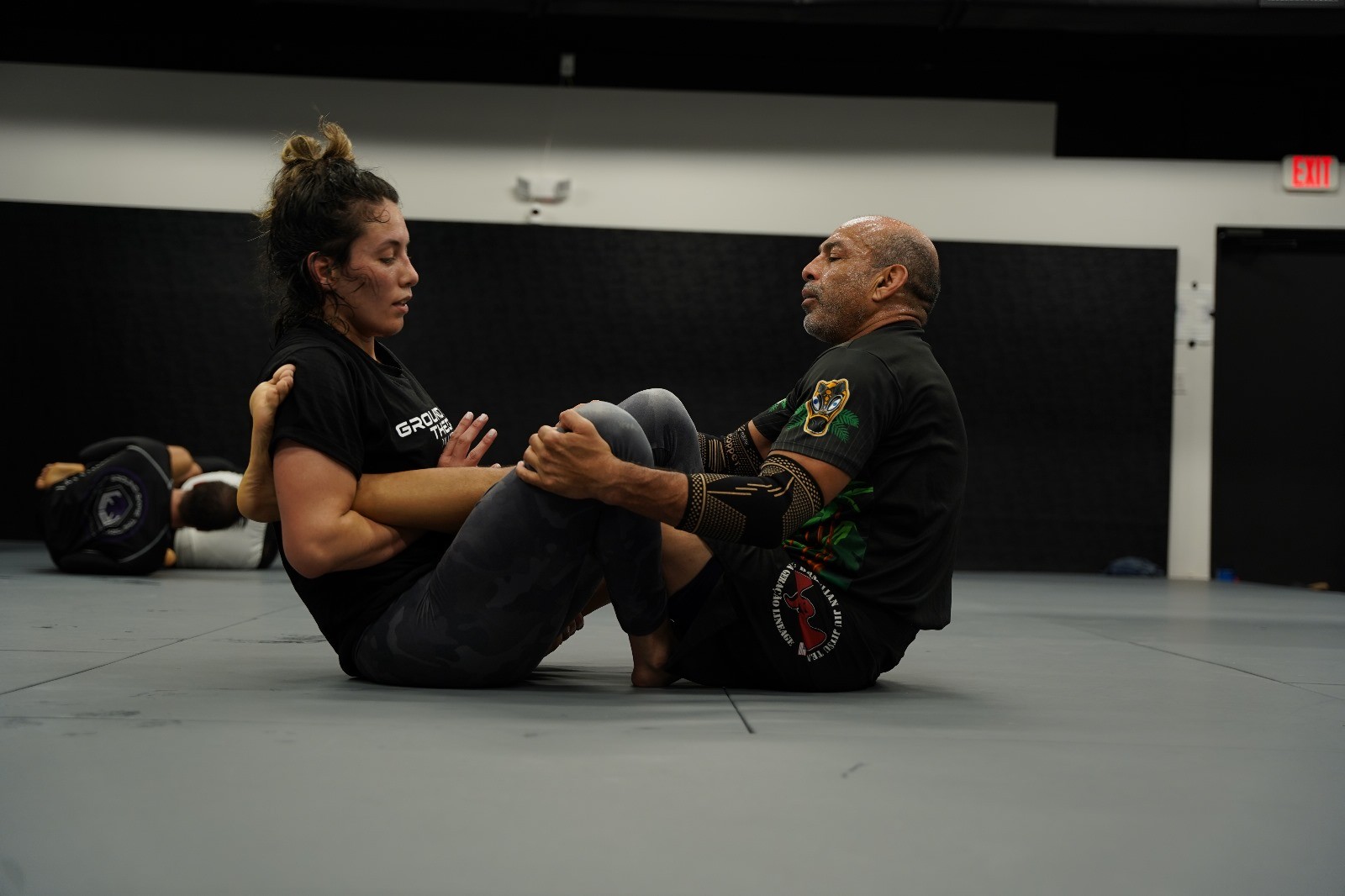 Jiu jitsu practitioners demonstrating a grappling technique in class.
